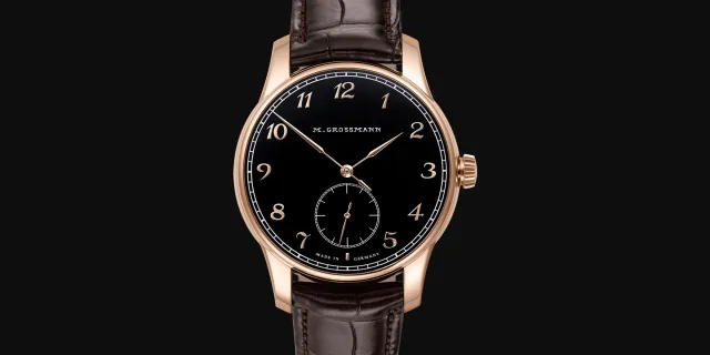 Moritz Grossmann Hamatic Enamel in Rotgold von vorne, schwarzes Emailzifferblatt mit arabischen Ziffern aus Gold